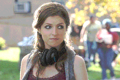 Beca (Anna Kendrick) from Pitch Perfect wearing a tank top and cardigan with headphones around her neck